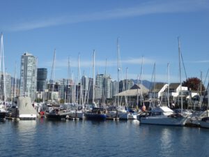 Zeilboten in een jachthaven aan False Creek met de skyline van Vancouver